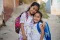 Dos chicas abrazadas con sus mochilas