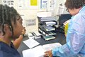 (L-R) A member of the POSGH team review records with Ms Valerie Wilson, Laboratory Expert, Caribbean MedLab Foundation