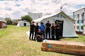 personas posando con una carpa detras
