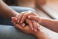 One person is offering support to another by holding his hands