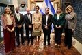 siete personas paradas en frente de la bandera de El Salvador