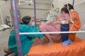 Mujer en trabajo de parto asistida por dos profesionales de la salud en el Hospital Intercultural de Atalaya, en Ucayali, Perú
