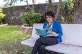 woman sitting on bench reading 