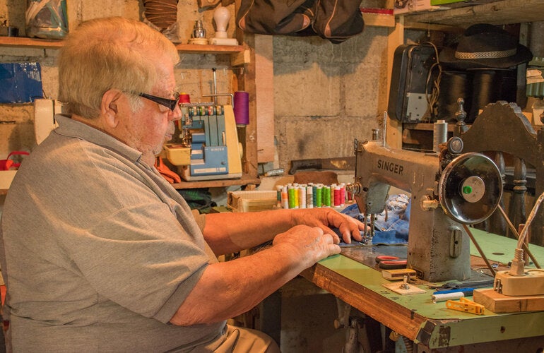 Hombre mayor cosiendo