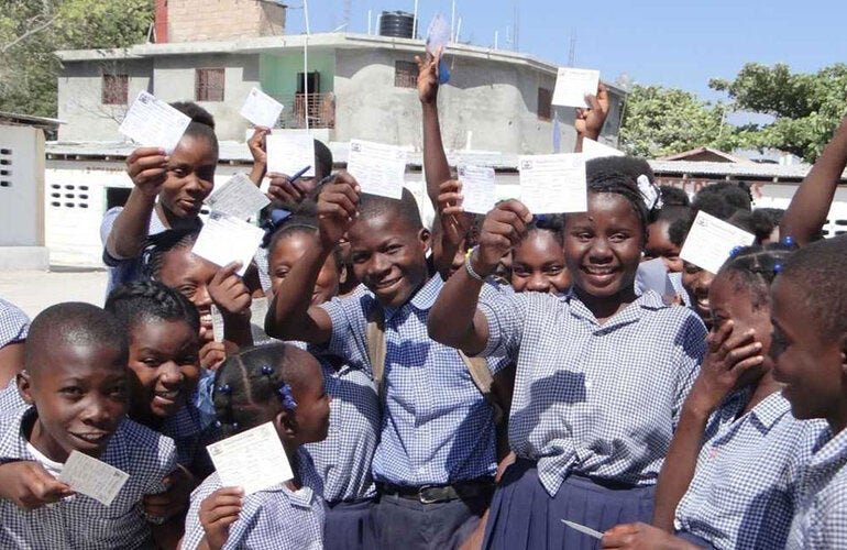 children holding up their vaccination cards