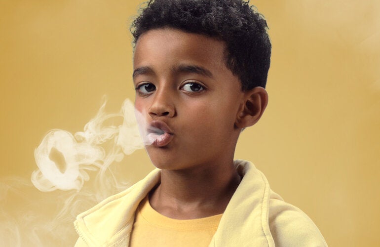Niño simulando fumar 