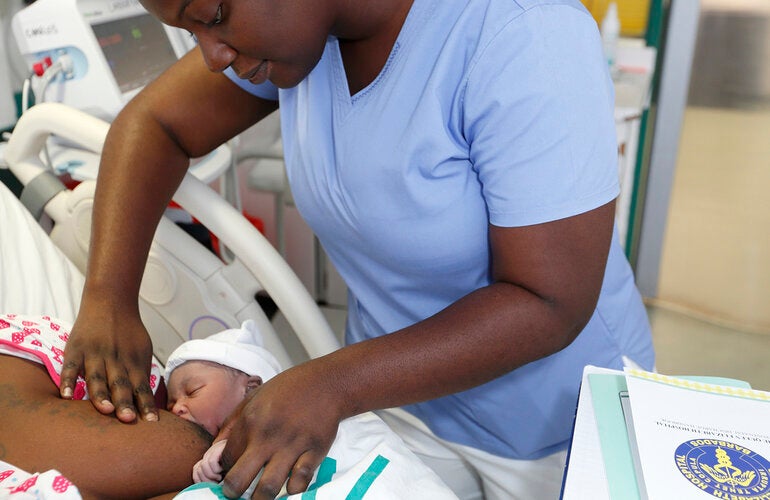 Nurse aids new mom with breastfeeding