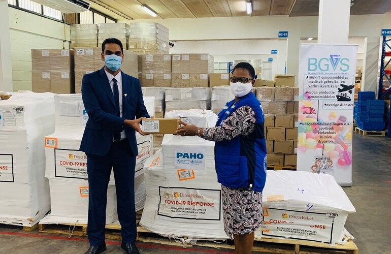 Dr. Karen Lewis-Bell, PAHO/WHO Representative in Suriname hands over a donation of COVID-19 supplies for case management to Dr. Amar Ramadhin, Minister of Health