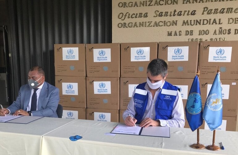 Representante de OPS y autoridad local durante entrega de las mascarillas