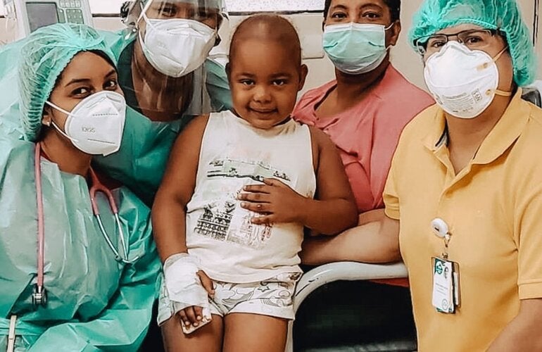 Young child with cancer with health personnel 