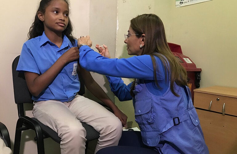 Representante vacunando a niña durante la inauguración 