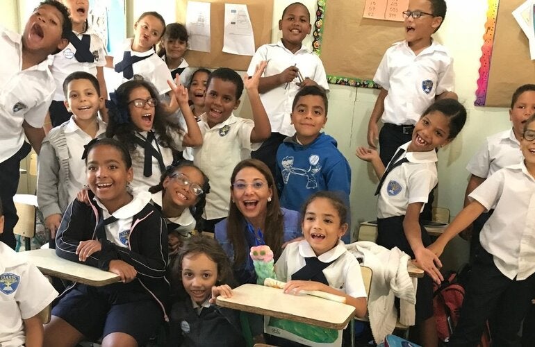 Representante junto a estudiantes de una escuela 