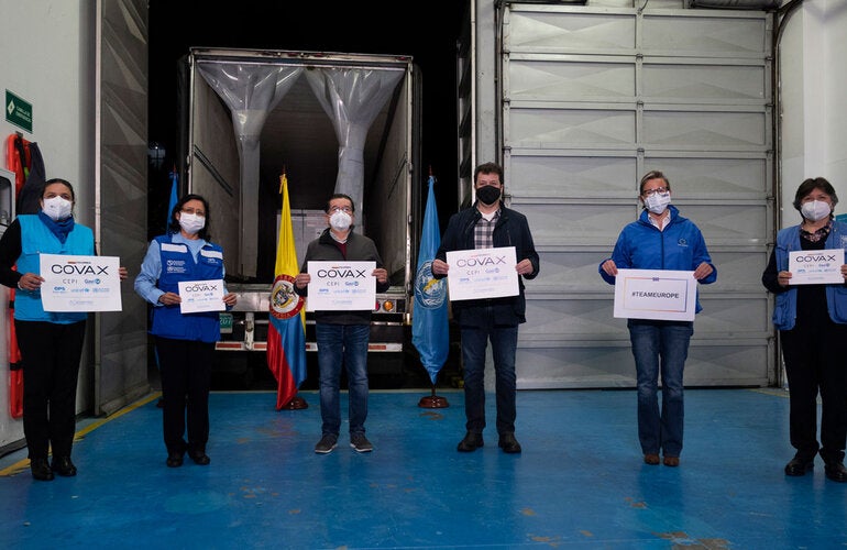 Personal de Entrega de Vacunas con letreros de COVAX