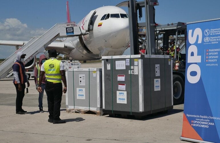 Contenedores de vacunas en pista de aeropuerto