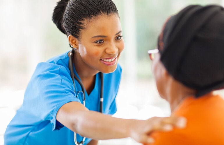 Nurse reaching out to comfort older patient