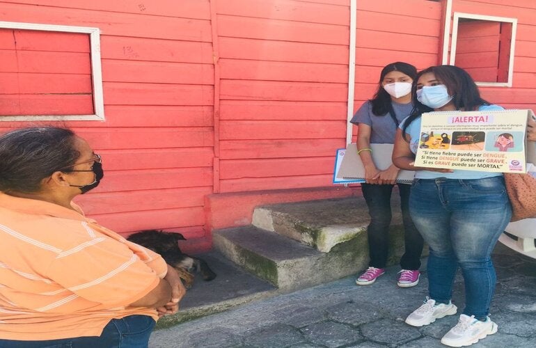 jóvenes promotores de salud, hablando en la comunidad sobre prevención del dengue y La COVID-19, usando rotafolio