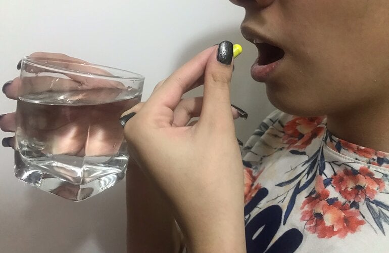 tomna de pastilla por parte de una mujer