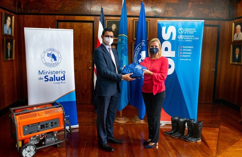 Representante OPS entregando donación a Ministro de Salud