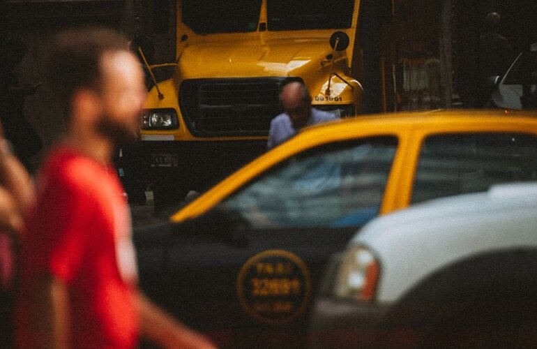 Personas y automóviles en la vía pública