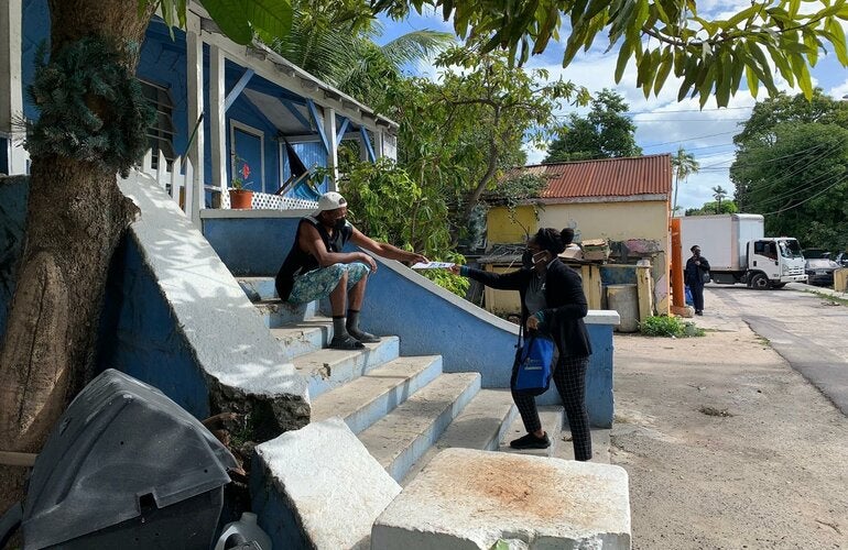 Healthcare worker sharing a vaccine pop-up flyer to a resident.
