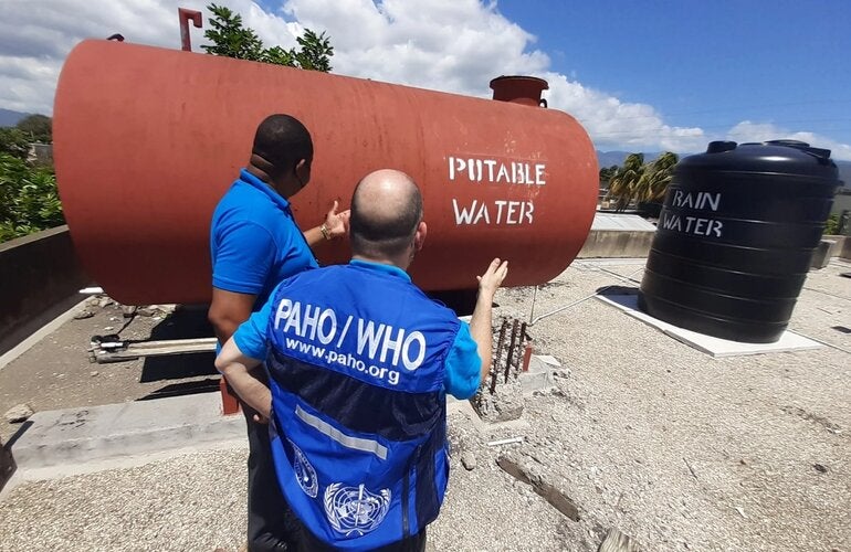 Representatives from the Pan American Health Organization/ World Health Organization Country Office in Jamaica view rainwater and potable water tanks on the roof of the Denham Town Health Centre