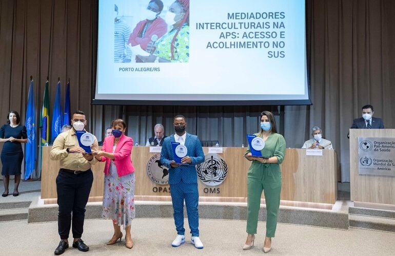 Representante da OPAS/OMS no Brasil entrega prêmio a um dos vencedores