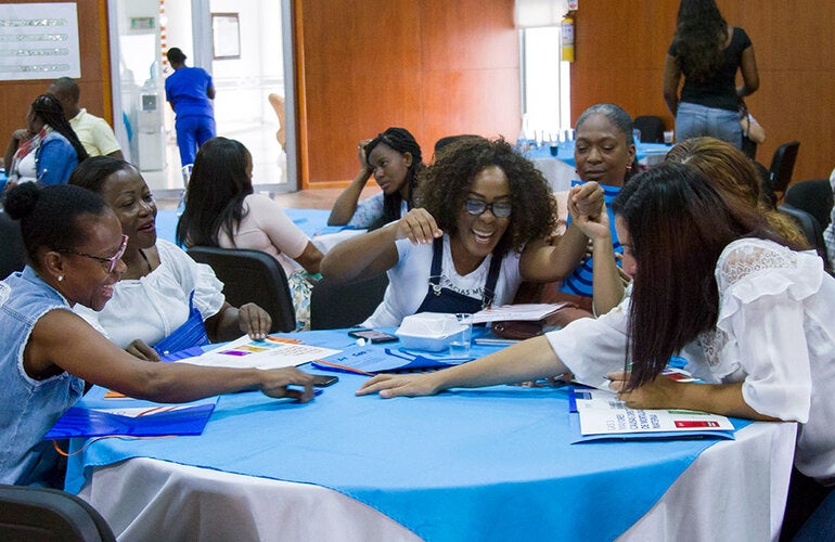 Women interacting seated around a table