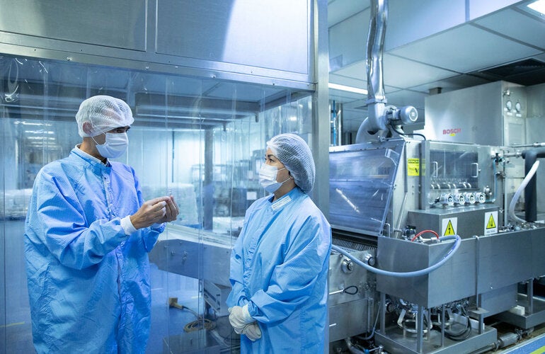 Diretor adjunto de Produção da Bio-Manguinhos-Fiocruz, trabalhando com um colega.