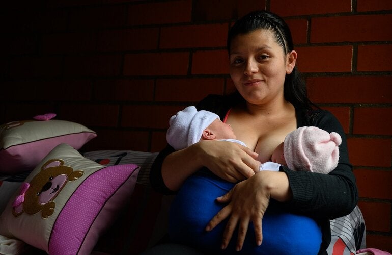 Mulher amamentando dois bebês