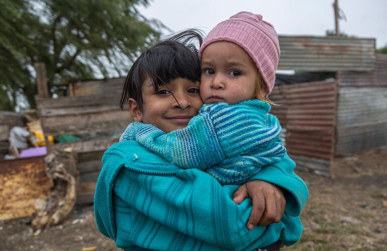 Girls with baby in her hands in impoverished area