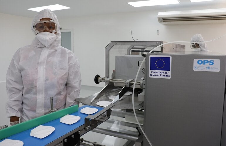 Operaria trabaja en línea de mascarillas