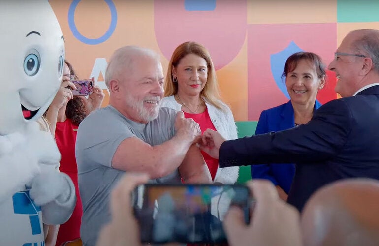 Presidente do Brasil recebe a vacina do vice-presidente, dra. Socorro Gross está entre os dois ao fundo