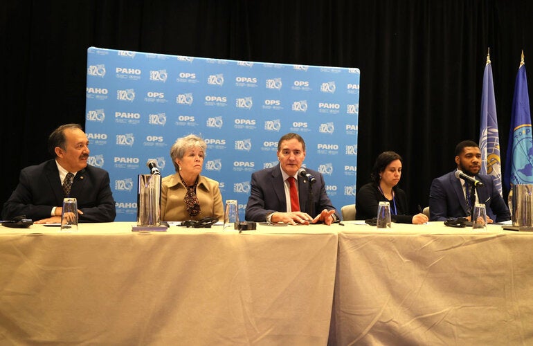 Grupo de autoridades de salud en mesa principal