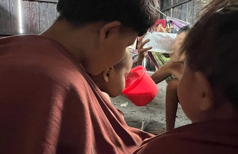 Criança Yanomami bebendo o leite terapêutico