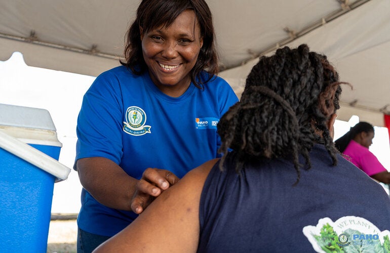 A nurse prepares to vaccinate an adult