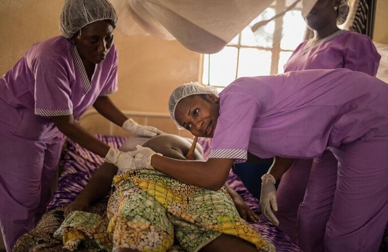 enfermeras o matronas junto a embarazada acostada