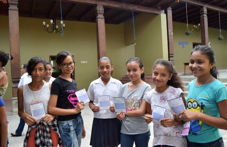 Niñas mostrando carnet de vacunación VPH