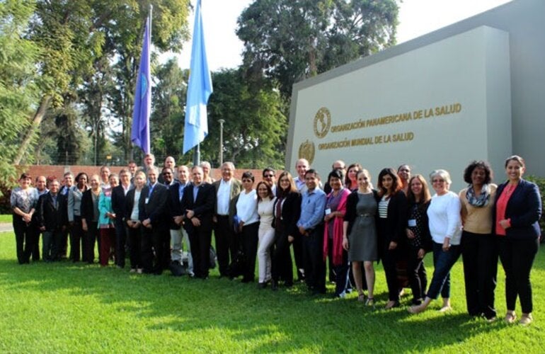 participantes de la reunion posan frente a la entrada oficina