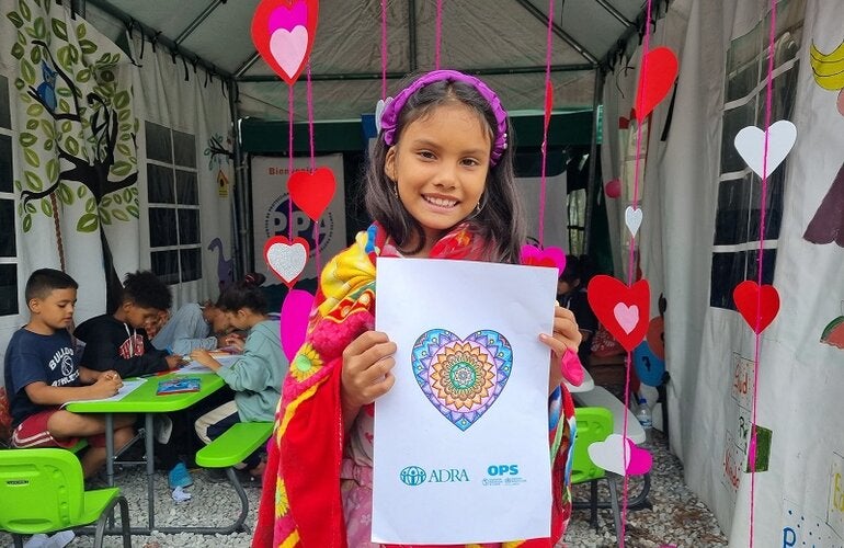 Niña migrante en Machuca, Ocotepeque, muestra su dibujo en jornada de salud mental