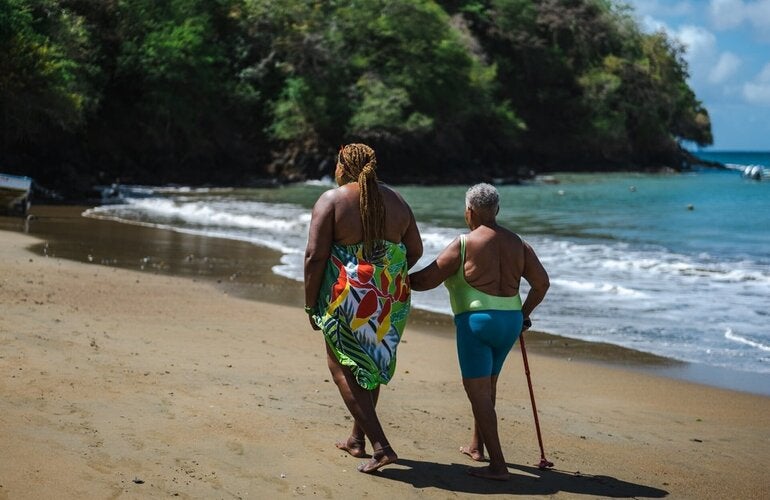 Arlene (en la parte izquierda de la imagen) se lleva a su madre siempre que puede en sus paseos a lo largo de la playa. Vivir en la localidad costera de Belle Garden (Tobago) les permite relajarse y hacer ejercicio.
