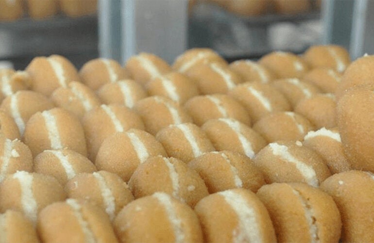 baking sheet full of cream-filled sugar-coated fried pastries