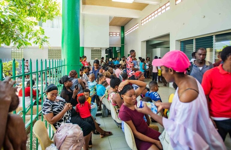 A crowd gathers at the gates of the HUP waiting for health care