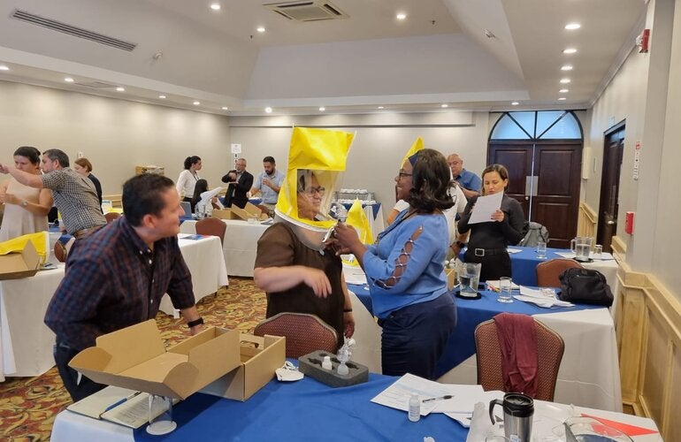 Large event room. Participants are learning how to use personal protection equipment on a respiratory protection training