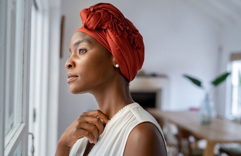 Woman with head turban looking out the window