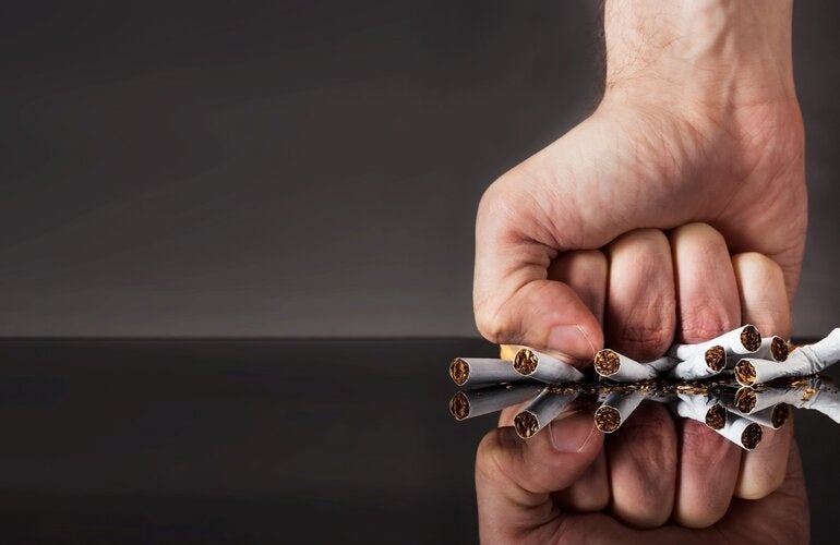 fist squeezing a bunch of cigarrettes