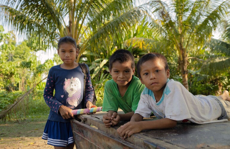 Una niña y dos niños en una zona costanera