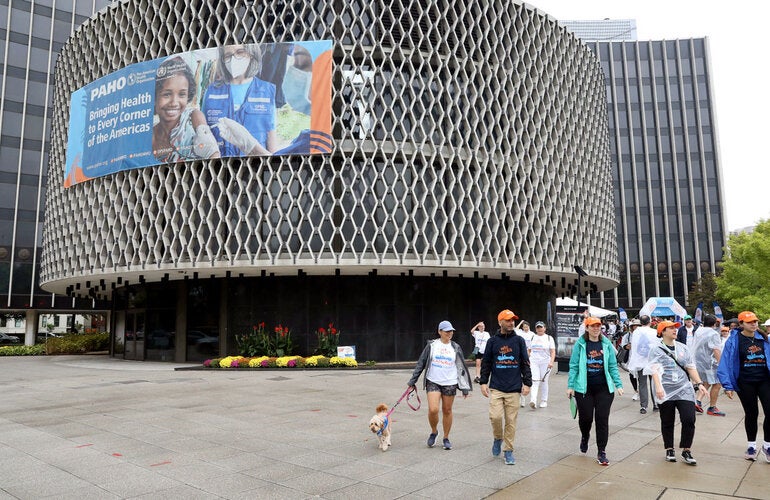 PAHO staff, family, and friends begin the Walk for Health. Behind is the PAHO HQ building.
