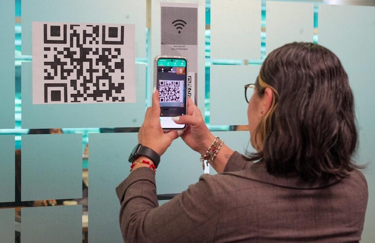 Funcionaria de la OPS toma foto de un código de QR