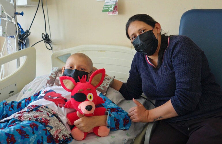 Mother with son, who is in a hospital bed