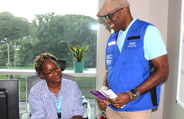 L-R (seated) Dr Ayanna Alexander , Technical Officer - Health Promotion, Life Course, and Determinants and (standing) Dr Stephen Nurse-Findlay, Advisor, Communicable Disease Control and Elimination review the printed Hansen’s disease communication materials.